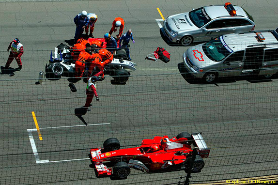 Михаэль Шумахер проезжает мимо разбитой машины своего брата Ральфа