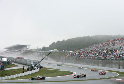 Льюис Хэмилтон лидирует на старте Гран При Японии 2007 года. Пилоты едут за машиной безопасности 