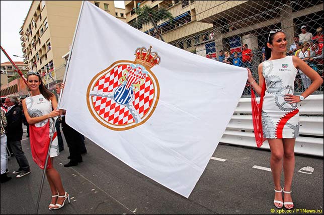 Девушки на стартовом поле с флагом организаторов гонки – автоклуба Монако