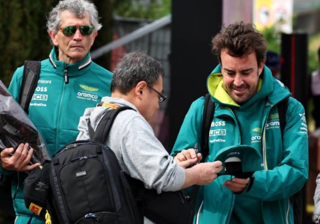 Фернандо Алонсо даёт автограф болельщику в паддоке Гран При Японии, фото XPB
