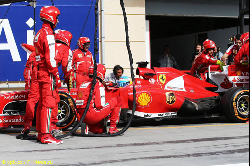 Механики Ferrari пытаются закрыть плоскость заднего крыла после отказа системы DRS на машине Фернандо Алонсо