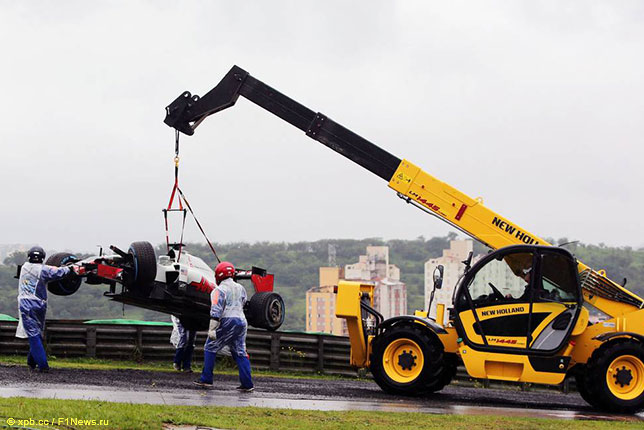 Машину Романа Грожана эвакуируют с трассы после аварии перед началом Гран При Бразилии