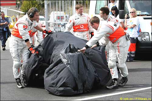 Механики McLaren закрывают разбитую машину Хейкки Ковалайнена