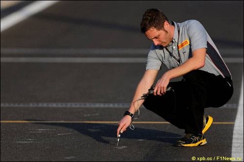 Сотрудник Pirelli измеряет температуру асфальта в Абу-Даби