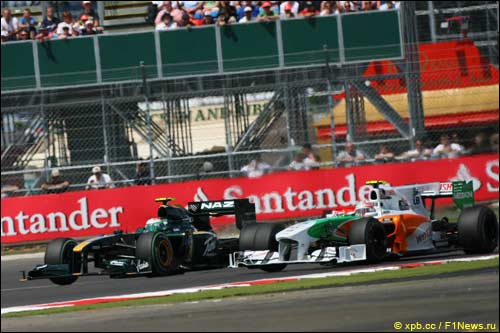 Машины Lotus Racing и Force India на трассе Гран При Великобритании в Сильверстоуне