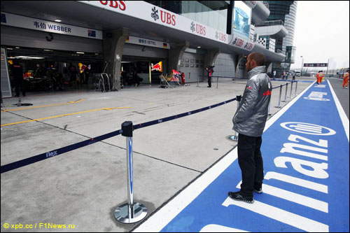 Льюис Хэмилтон изучает временную разметку перед боксами Red Bull Racing на Гран При Китая