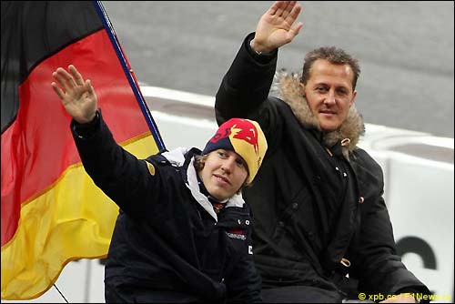Себастьян Феттель и Михаэль Шумахер приветствуют болельщиков перед стартом Гонки Чемпионов