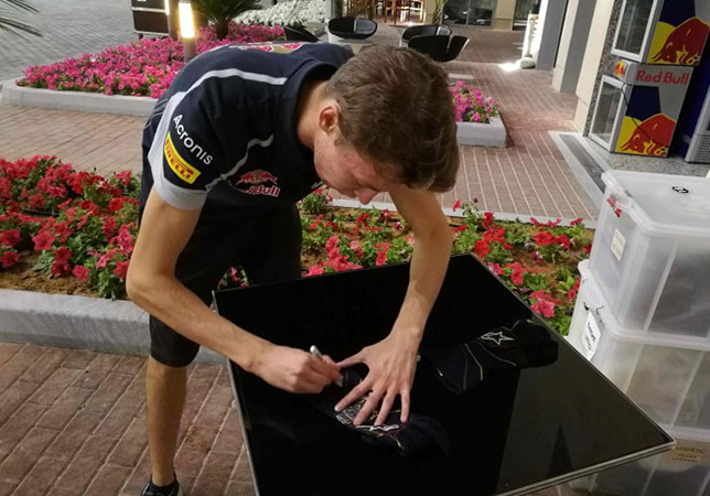 Даниил Квят подписывает свои гоночные перчатки после Гран При Абу-Даби