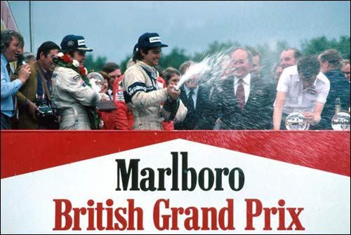 Алан Джонс, Нельсон Пике и (скрытый последним) Карлос Рейтеман на подиуме Гран При Великобритании 1980 года