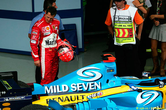 Михаэль Шумахер рассматривает машину Фернандо Алонсо