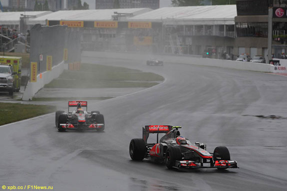 Машины McLaren на залитой дождём трассе в Монреале