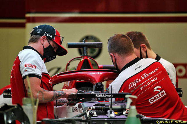 Кими Райкконен (слева) помогает механикам Alfa Romeo работать с его машиной