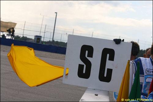 Желтый флаг и табличка, предупреждающая о появлении автомобиля безопасности