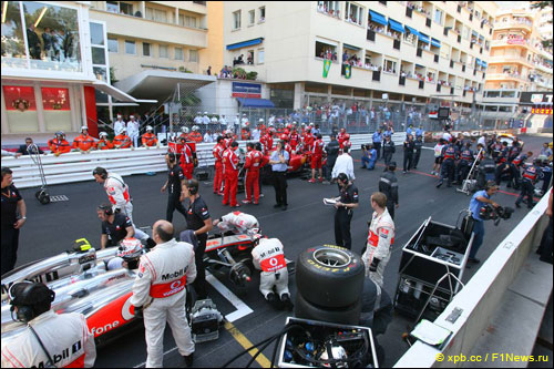Механики работают с машинами во время паузы по ходу гонки в Монако