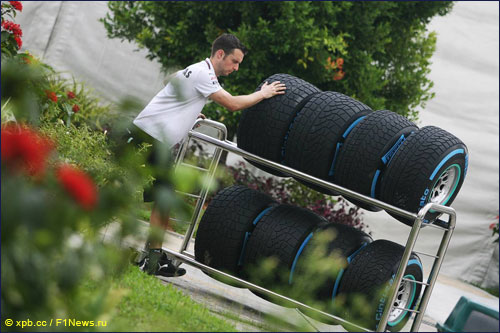 Механик Mercedes везет тележку с шинами в паддоке Гран При Малайзии