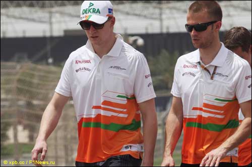 Нико Хюлкенберг (слева) вместе с гоночными инженерами обходит бахрейнскую трассу