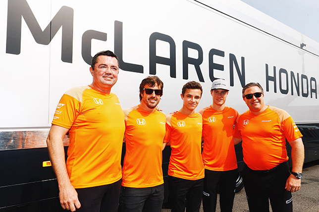 Ландо Норрис (в центре) вместе с руководителями и гонщиками McLaren - Эриком Булье, Стоффелем Вандорном, Фернандо Алонсо и Заком