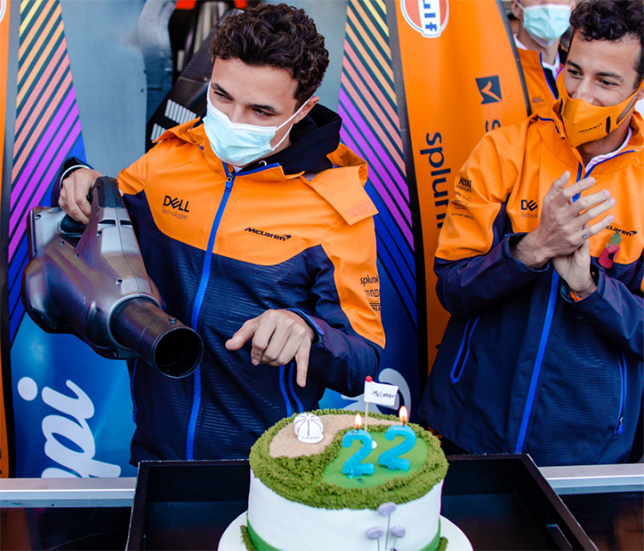 Ландо Норрис задувает свечки на торте, фото из Twitter команды McLaren