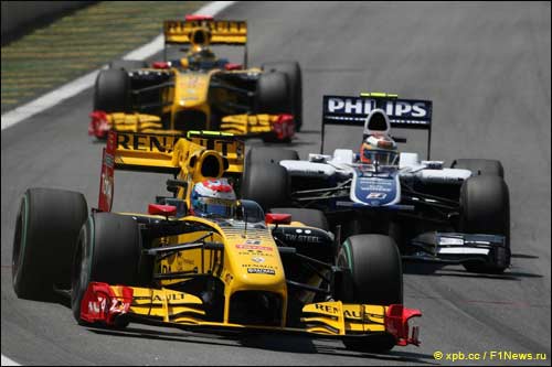 Пилоты Renault F1 Петров (на переднем плане) и Кубица ведут борьбу с обладателем поула Хюлкенбергом на трассе Интерлагос